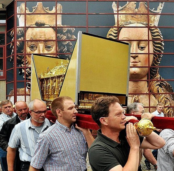 Wie bei den Prozessionen während des Liborifestes schleppen acht Schrein-Träger das wertvolle Behältnis aus dem Diözesan-Museum. Zwei Schutzkappen aus Polyester schützen bei diesem Gang den Deckel des frisch restaurierten Schreins, der zuvor mit vier Schrauben auf dem 30 Kilogramm schweren Gestell befestigt wurde. Denn im Dom ist eine steile Treppe zu überwinden. - © FOTO: REINHARD ROHLF