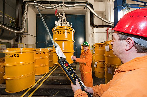 Norman Rueß (r.) verlädt mit einem Kran ein 200-Liter-Fass mit Atommüll. Armin Müller (l.) nimmt eine Wischprobe. - © FOTO: CHRISTIAN WEISCHE
