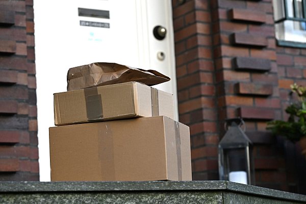 Drei Pakete liegen vor einer Haustür - für Paketfirmen ist dieser Lieferweg eine teure Sache. (Archivbild) - © Wolf von Dewitz/dpa