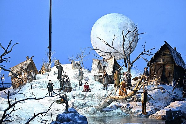 Auf dem Bodensee ist für die Inszenierung ein halb im Wasser versunkenes Dorf entstanden - mit schneebedeckten Hütten, kahlen Bäumen und einem riesigen Mond. - © Felix Kästle/dpa