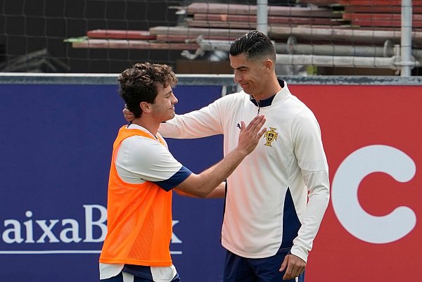 Portugals Kapitän Cristiano Ronaldo (r) mit Champions-League-Sieger Joao Neves beim Training. - © Armando Franca/AP/dpa