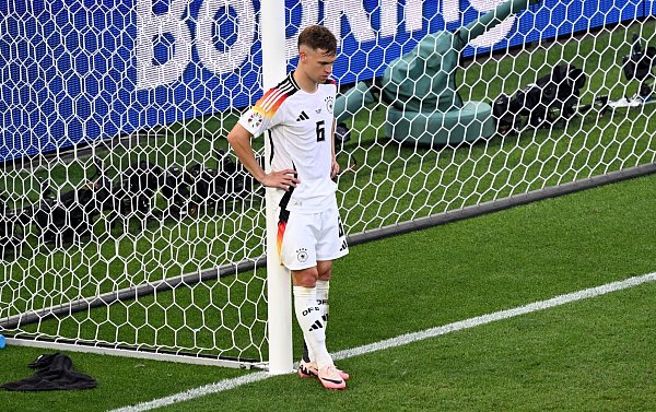 Deutschlands Joshua Kimmich steht nach dem EM-Aus enttäuscht auf dem Platz. - © Bernd Weißbrod/dpa