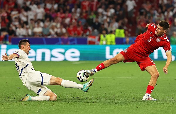 Serbiens Srdjan Mijailovic (l) und der Däne Joakim Maehle gehen beide mit vollem Einsatz zum Ball. - © Daniel Löb/dpa