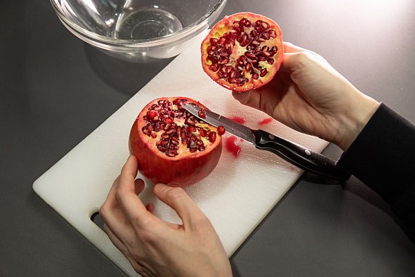 Schritt 1: Die obere Kappe des Granatapfels abschneiden und den Deckel abnehmen. - © Christin Klose/dpa-tmn