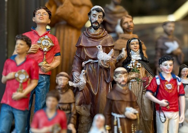 Figuren des alten und des neuen Heiligen stehen in den Souvenirhops nebeneinander. (Foto: Archiv) - © Christoph Sator/dpa