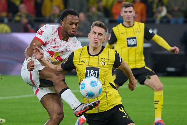 Dortmunds Nico Schlotterbeck und Lois Openda (l) von Leipzig kämpfen um den Ball und den Sieg im Topspiel. - © Bernd Thissen/dpa