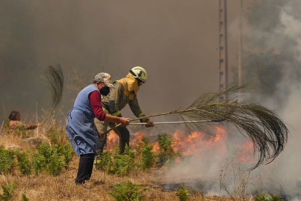 Einsatzkräfte, freiwillige Helfer und betroffene Anwohner kämpfen unermüdlich gegen die Flamen. - © Pablo Garcia/AP/dpa