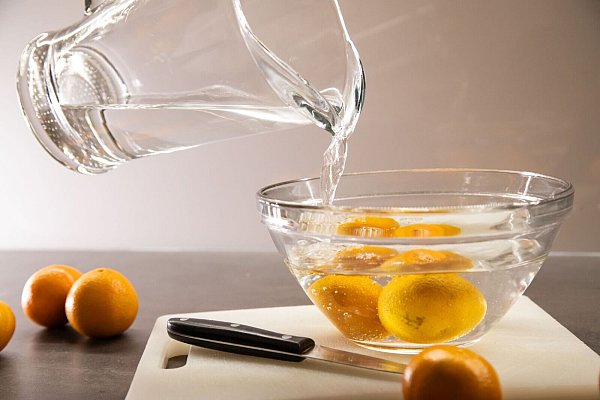 Schritt 1: Heißes Wasser über die Clementinen gießen und eine Minute ziehen lassen. - © Christin Klose/dpa-tmn