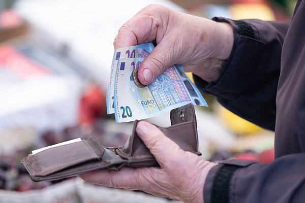 Eine Frau sortiert auf einem Wochenmarkt das Wechselgeld für ihre Einkäufe in ein Portemonnaie. - © Sebastian Kahnert/dpa