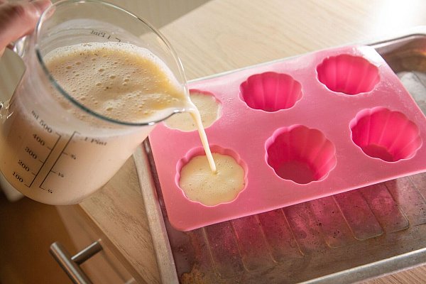 Die Masse für die Vanille-Panna Cotta wird in die Sillikonform gegossen. - © Christin Klose/dpa-tmn