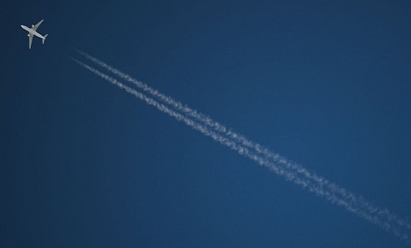 Ein Passagierflugzeug hinterlässt beim Flug CO2 und Kondensstreifen. (Archivbild) - © Arne Dedert/dpa