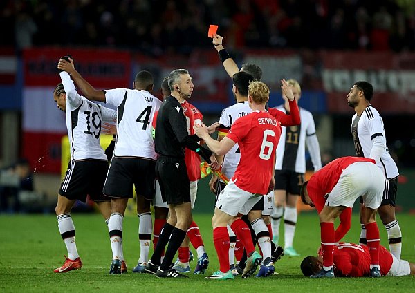 Deutschlands Leroy Sané (l) sah nach einer Tätlichkeit an Österreichs Phillipp Mwene die Rote Karte. - © Christian Charisius/dpa