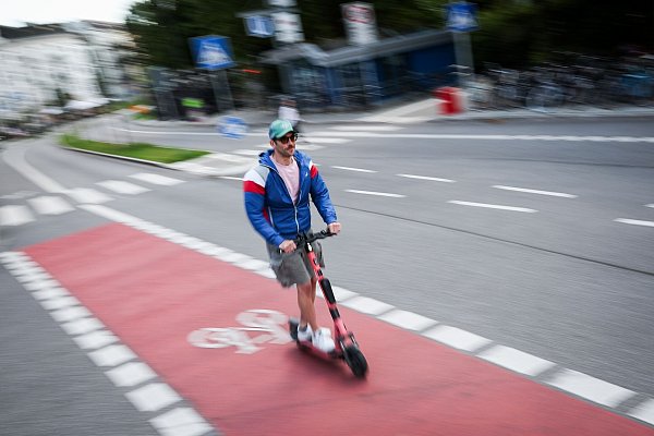 Ein Mann fährt auf einem Radweg in Hamburg mit einem E-Scooter. - © Christian Charisius/dpa