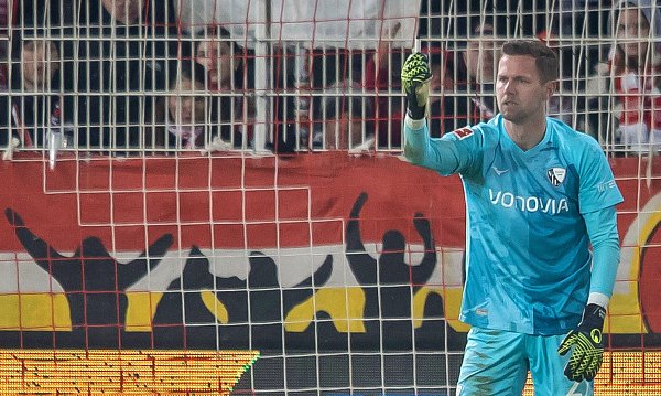 Bochums Keeper Patrick Drewes das Feuerzeug hoch, das ihn getroffen hat. - © Andreas Gora/dpa