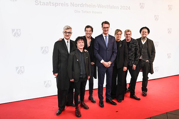 Ministerpräsident Hendrik Wüst (CDU) und Regisseur Wim Wenders lobten das Engagement der Band. - © Oliver Berg/dpa