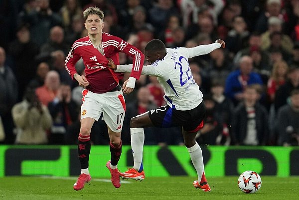 Textiltest: Lyons Clinton Mata (r) zupft am Trikot von ManU-Spieler Alejandro Garnacho. - © Jon Super/AP/dpa