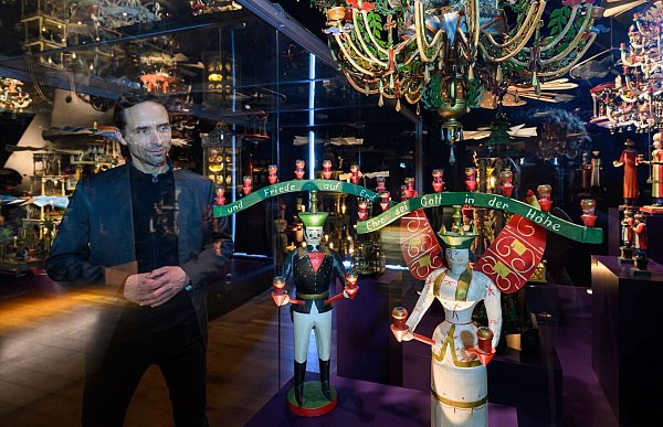 Bastian Guthke, Museumspädagoge, steht in der Ausstellung der «Manufaktur der Träume» in Annaberg-Buchholz zwischen historischen Figuren, Pyramiden und Leuchtern. - © Hendrik Schmidt/dpa