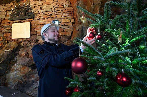 Schmücken, auch unter Tage: Gunnar Lenhard und Weihnachtsbaum im Markus-Röhling-Stolln. - © Hendrik Schmidt/dpa