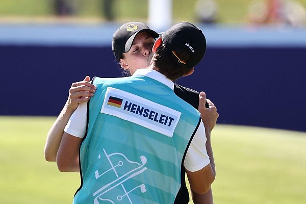 Esther Henseleit (l) küsst ihren Freund und Caddie Reece Phillips. - © Jan Woitas/dpa