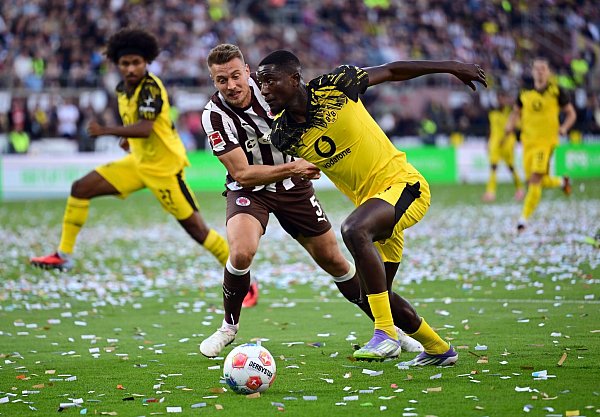 St. Paulis Hauke Wahl (l) im Zweikampf mit BVB-Stürmer Serhou Guirassy. - © Sina Schuldt/dpa