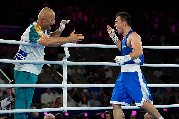 Hasanboy Dusmatov (r) gewann in Paris Gold, sein Trainer Tulkin Kilichev kollabierte bei der anschließenden Feier. - © John Locher/AP/dpa