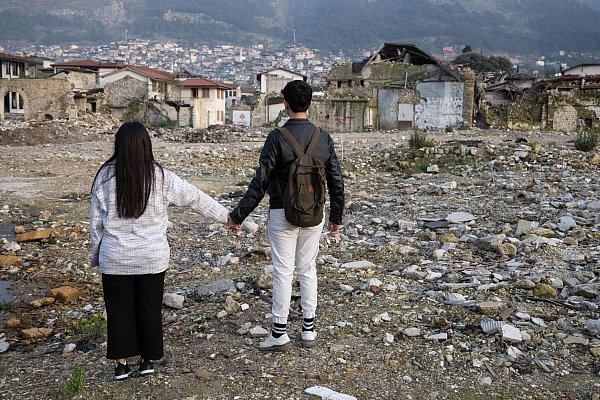 Die Geschwister Arzu (l) und Mehmet stehen in den Trümmern der Altstadt von Antakya. Beide waren bei dem Beben vor einem Jahr verschüttet worden. - © Boris Roessler/dpa
