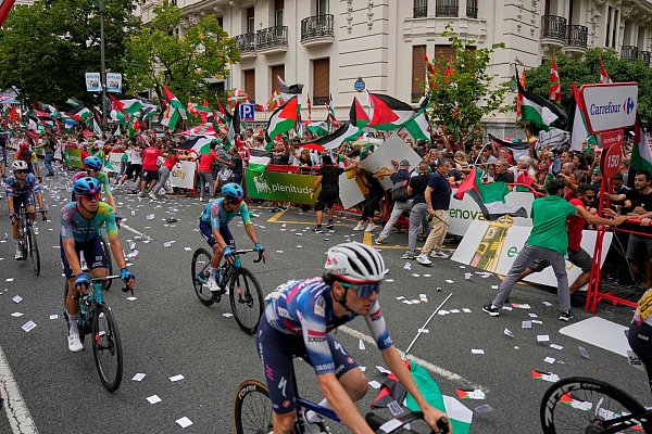 Demonstranten mit palästinensischen Fahnen sorgen bei der Vuelta für chaotische Zustände. - © Miguel Oses/AP/dpa