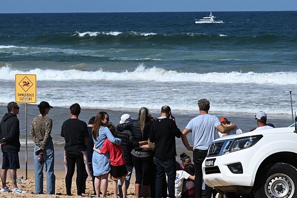 Schockierte Familienangehörige und Freunde trauerten am Strand um das Opfer. - © Dean Lewins/AAP/dpa