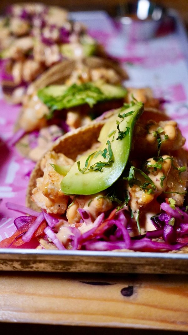 Es muss nicht immer gezupftes Fleisch sein: Auch kleine gebratene Fisch-Flöckchen mit Avocado machen den Taco lecker. - © Andres Besson/dpa-tmn