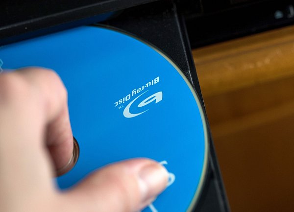 Am Besten die DVD am Rand oder dem Loch in der Mitte halten - so bleibt die Oberfläche frei von Fingerabdrücken. - © Christin Klose/dpa-tmn