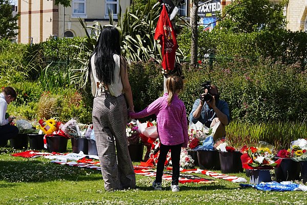 Im Laufe des Tages legten immer mehr Menschen Blumen und Fanartikel nieder. - © Peter Byrne/PA Wire/dpa