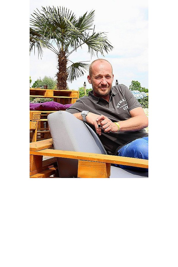 Alexander Hundt ist Strandgut-Betreiber und Heimwerker. Sofas und hohe Tische hat er mit Freunden gebaut. - © FOTO: SEBASTIAN BEUG