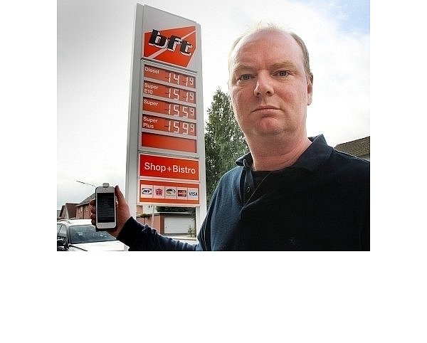 Werner Mersch, Betreiber der Bft-Tankstelle in Schloß Holte-Stukenbrock, kontrolliert auf dem Handy, wie schnell die aktuellen Spritpreise im Internet sind und ob sie mit den Angaben auf der Anzeigetafel übereinstimmen. - © FOTO: AMINA VIETH