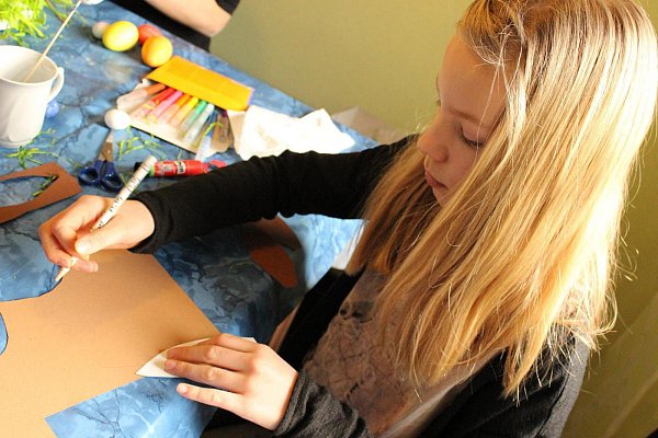Leckere Schoko-Hasen: Um den Schokokuss-Hasen flauschige Ohren zu verpassen, schneidet Emily (8) jeweils zwei Ohren pro Hase aus Tonkarton aus und beklebt sie mit Bastelwatte. - © Corinna Schwanhold