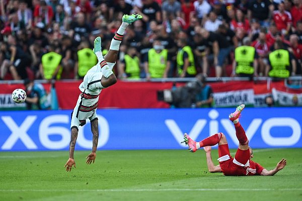 Nach einem Zweikampf mit dem Ungarn Tamas Cseri fliegt der Portugiese Nelson Semedo (l) durch die Luft. - © Robert Michael/dpa-Zentralbild/dpa