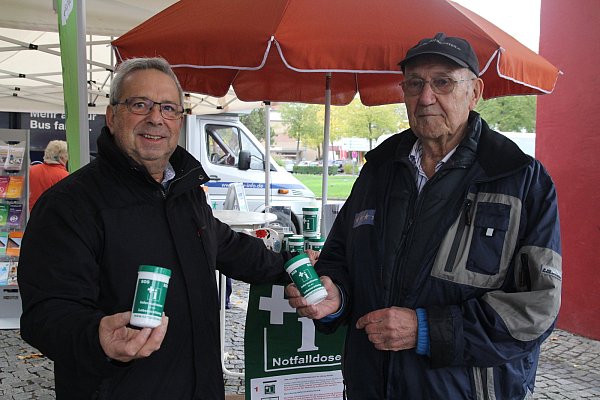 Gehört in jeden Haushalt: Rolf Wedhorn (l.) und Gunter Kramer (r.) verteilten gegen eine Spende Notfalldosen, die die wichtigsten Informationen und Daten für den Ernstfall enthalten. - © Klaus Frensing