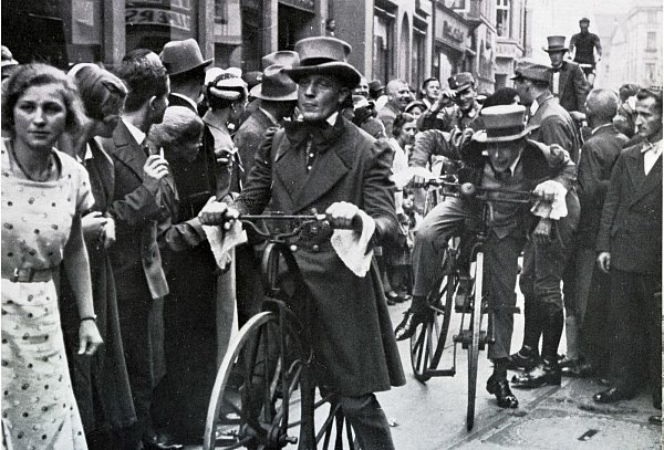 Historisches Foto zum Tag des Fahrrades 1935 in Bielefeld. Dicht gedrängt standen die Menschen in der Obernstraße, um den historischen Umzug zu sehen. Viele 1000 Menschen waren auf den Beinen. Hier ist die „Fahrmaschine“ des Freiherrn von Drais zu sehen. Die Fahrradfahrer hatten historische Kostüme angezogen. - © Stadtarchiv Bielefeld