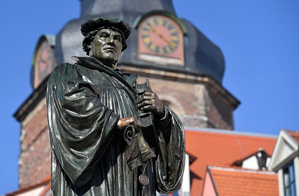 An prominenter Stelle auf dem Marktplatz der Lutherstadt Eisleben erinnert ein Denkmal an den Reformator Martin Luther. - © dpa