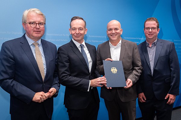 Flughafen-Geschäftsführer Roland Hüser (2. v. r.) und Projektleiter Matthias Fleige (r.) nehmen den Förderbescheid im Beisein des Bundestagsabgeordneten Frank Schäffler (l.) von Bundesminister Volker Wissing (beide FDP) entgegen. - ©BMDV/Woithe