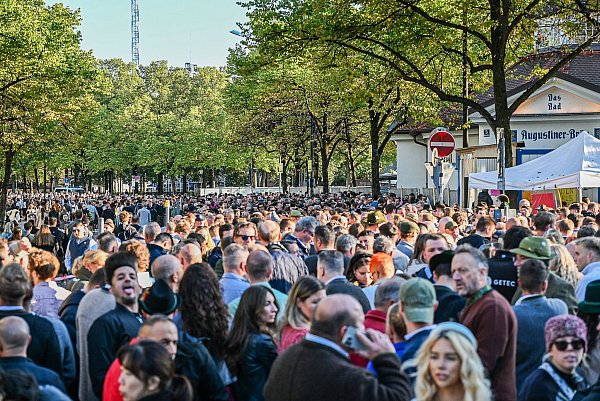 Zahlreiche Besucher warten vor einem Eingang auf den Einlass zum Gelände des Oktoberfests. - © Jason Tschepljakow/dpa