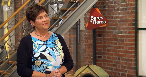 Monika Gräbner-Thieme stellt sich der Händlerrunde bei "Bares für Rares". Das Interesse an ihrer Krawattennadel ist groß. - © Screenshot/ZDF Mediathek
