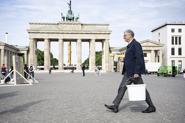 Dieses von der Entwicklungshilfe-Organisation ONE zur Verfügung gestellte Foto zeigt Bill Gates mit einem Eimer bei einer Plakataktion zur Entwicklungspolitik vor dem Brandenburger Tor. - © picture alliance/dpa/ONE