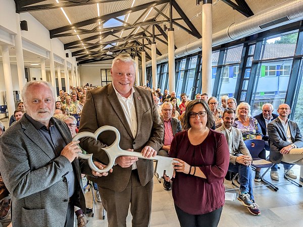 Architekt Werner Schmidt übergibt den symbolischen Schlüssel an Höxters Bürgermeister Daniel Hartmann und Schulleiterin Bettina Becker. - © Burkhard Battran