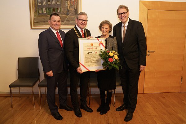 Der Stadtsportverbandsvorsitzende Mathias Hornberger (v. l.), Bürgermeister Michael Dreier und Markus Mertens, Vorsitzender des Sportausschusses, überreichen Ingrid Knetsch für ihre jahrzehntelangen Verdienste um den Ostwestfälischen Turngau und das Turnen in der Sportstadt Paderborn sowie in der Region eine Urkunde zur Würdigung ihrer Leistungen. - © Stadt Paderborn