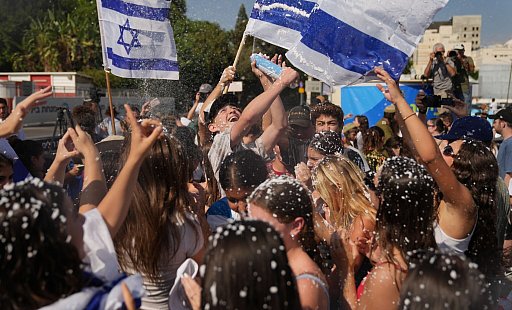 Menschen schwenken israelische Flaggen und versprühen Schaum nach der Ankunft der befreiten Geiseln im Beilinson-Krankenhaus in Petah Tikva. - Francisco Seco/AP/dpa