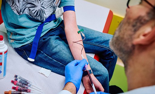 Ein Arzt nimmt bei einem Patienten eine Blutprobe. - picture alliance/dpa