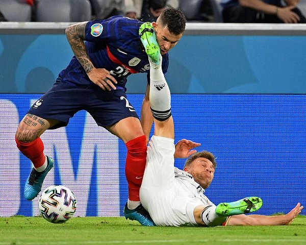 Der Franzose Lucas Hernandez (l) bringt Joshua Kimmich zu Fall und bekommt dabei dessen Schuh ins Gesicht. - © Franck Fife/AFP Pool/AP/dpa