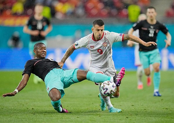 Österreichs David Alaba (l) und Aleksandar Trajkovski von Nordmazedonien kämpfen um den Ball. - © Vadim Ghirda/AP Pool/dpa