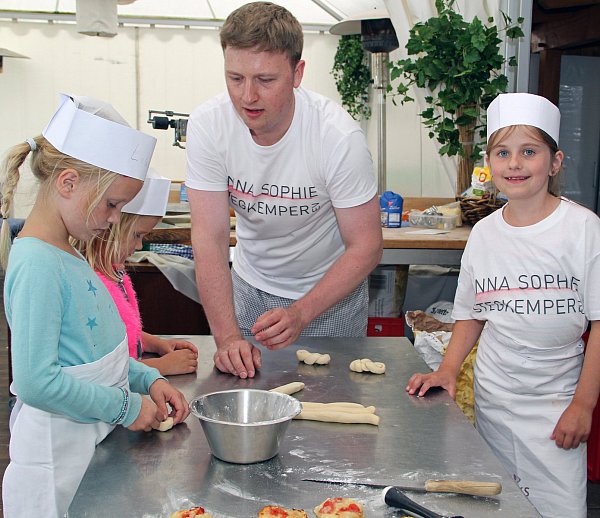 So wird?s gemacht: Christian Stegkemper ist gelernter Bäcker und zeigt den Jüngsten, wie man Teig flechten kann. - © Claudia Hecke
