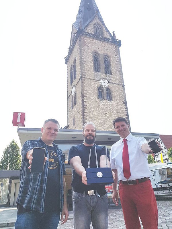 Geschafft: IT-Fachmann Christian Bierwirth (v. l.), Marcus Büenfeld vom Verein Freifunk Hochstift und Bürgermeister Michael Stickeln freuen sich über freies Internet auf dem Neustadtmarktplatz. - © Katharina Engelhardt
